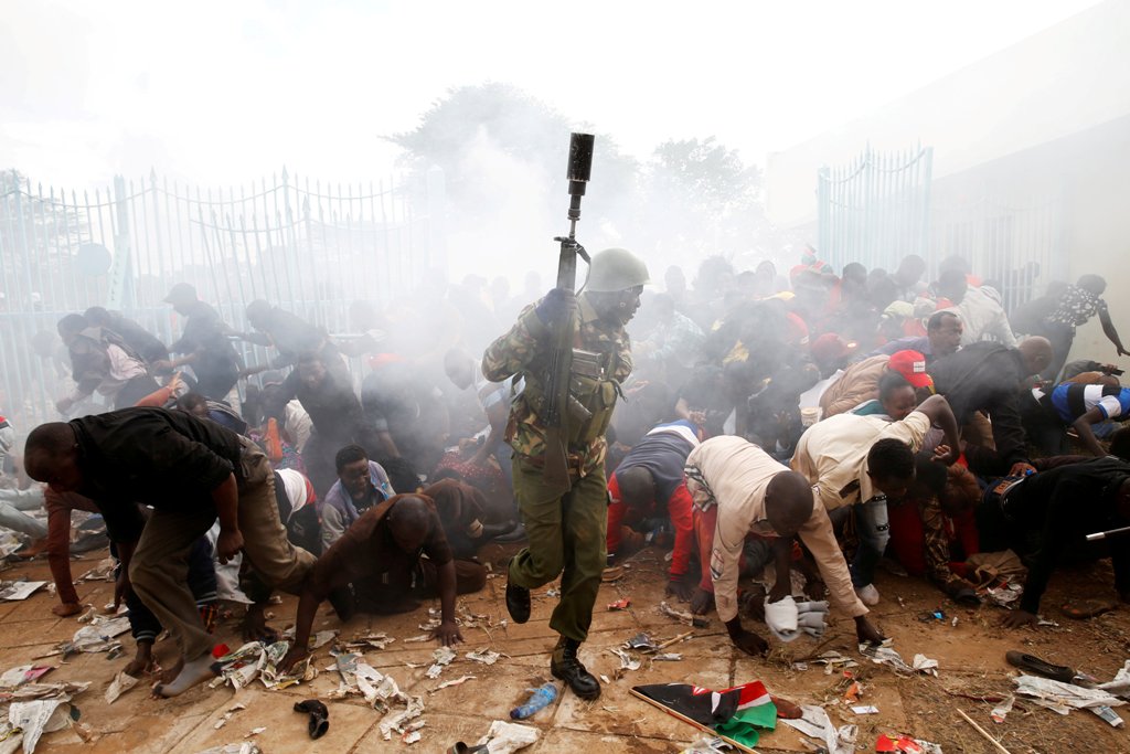 People fall as police fire tear gas to try control a crowd trying to force their way into a stadium to attend the inauguration of President Uhuru Kenyatta at Kasarani Stadium in Nairobi, Kenya November 28, 2017. REUTERS.