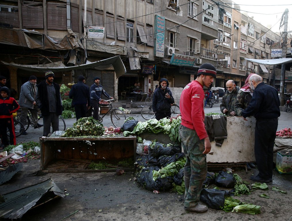 People gather at a damaged site after an airstrike in the rebel-held besieged town of Douma, eastern Ghouta in Damascus, Syria, November 27, 2017. REUTERS/Bassam Khabieh
