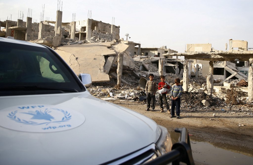 Boys stand next to debris of damaged buildings in the town of Nashabiyeh, eastern Ghouta in Damascus, Syria, November 28, 2017. REUTERS/Bassam Khabieh