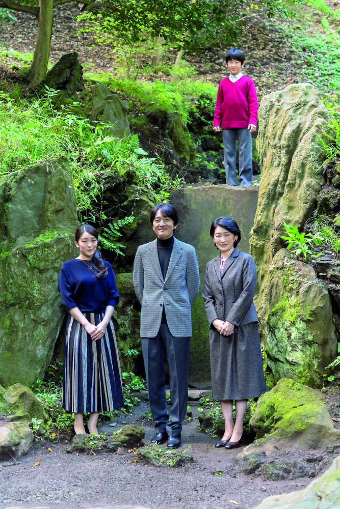 Japan's Prince Akishino (front C) and his wife Princess Kiko (front R) stroll in the garden for a family photo with their children Prince Hisahito (top) and Princess Mako, at their residence in Akasaka Imperial Grounds in Tokyo, Japan, in this handout pho