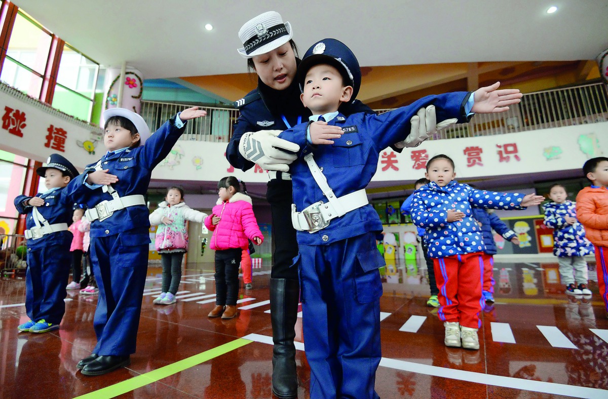 In this picture taken on November 29, 2017, a traffic warden teaches traffic laws and regulations to children in a kindergarten in Handan, Hebei province. AFP 
