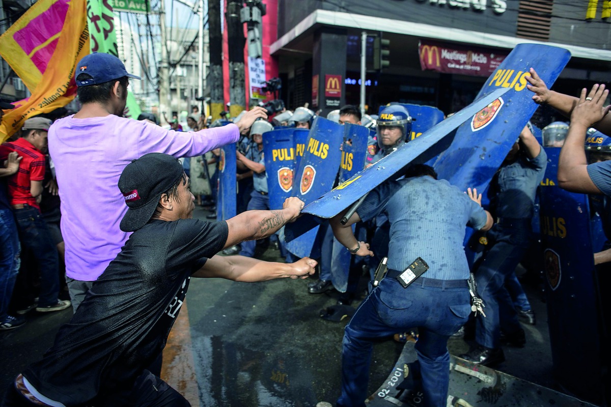 Activists scuffle with policemen during an anti-Duterte protest in Manila on November 30, 2017, denouncing the government's crackdown of activists and what they call US-backed Duterte dictartorship.  AFP / Noel Celis