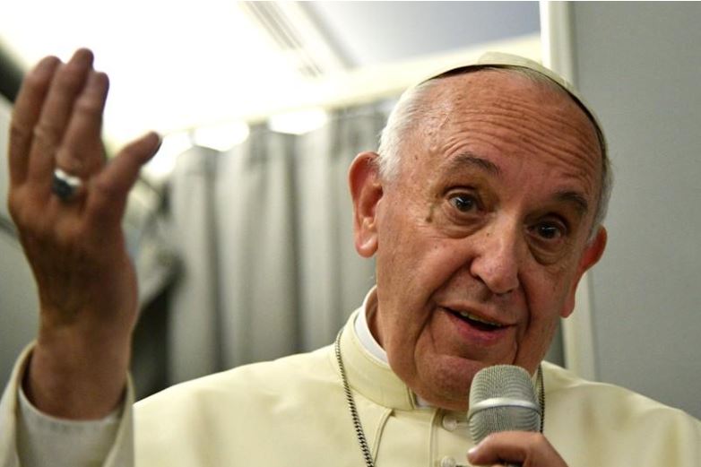 Pope Francis gestures during a news conference on board of the plane during his flight back from a trip to Myanmar and Bangladesh, December 2, 2017. REUTERS/Vincenzo Pinto/Pool.