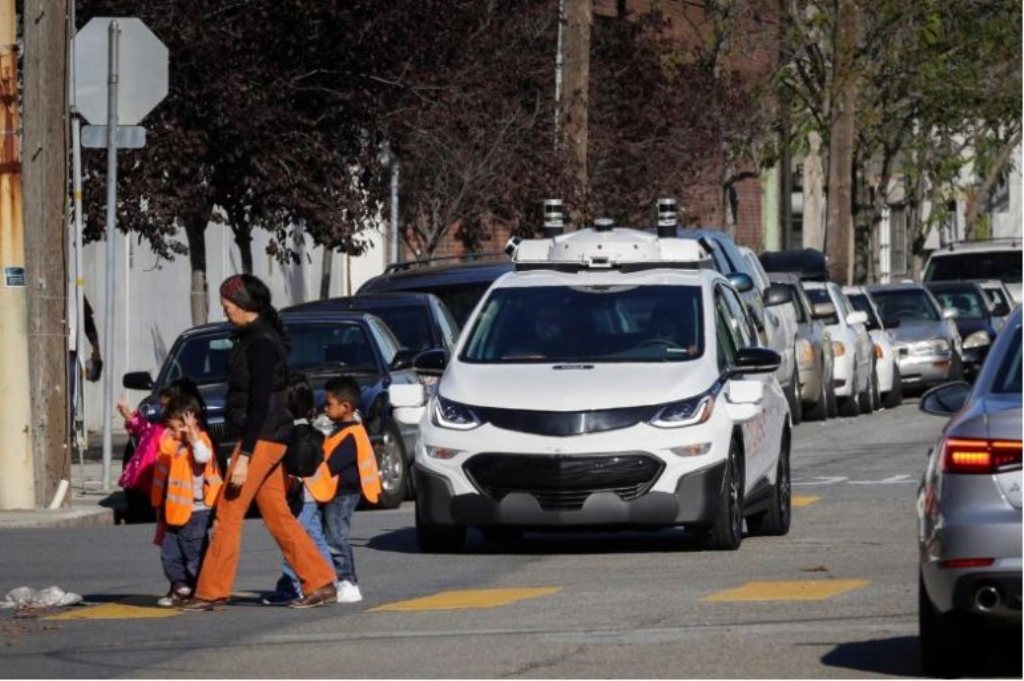 Children pass by a self-driving Chevy Bolt EV car during a media event by Cruise, GM’s autonomous car unit, in San Francisco, California, U.S. on November 28, 2017. REUTERS/Elijah Nouvelage/File Photo