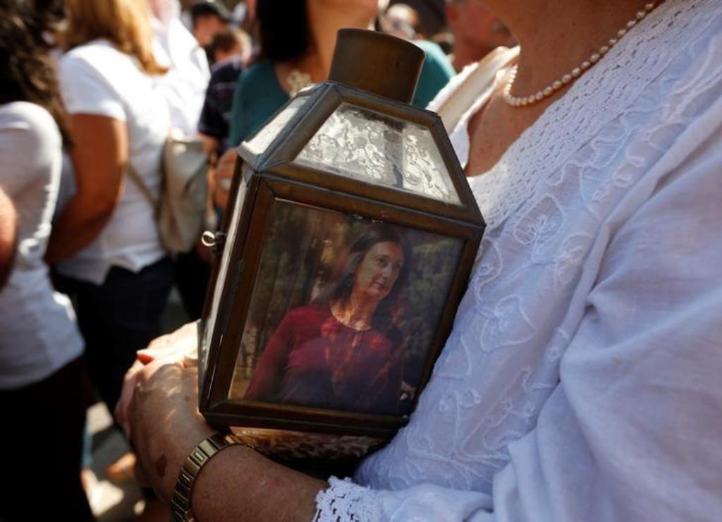 A woman holds a lantern with a picture of investigative journalist Daphne Caruana Galizia, who was assassinated in a car bomb attack, during a protest outside the law courts in Valletta, Malta, October 17, 2017. REUTERS/Darrin Zammit Lupi.