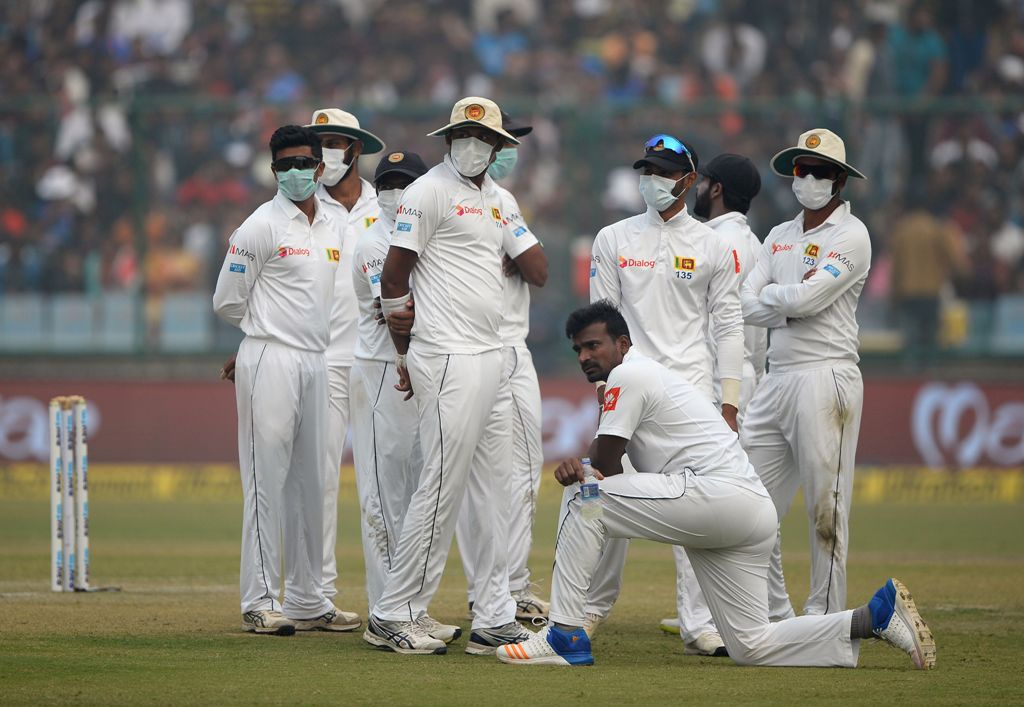 An image of Sri Lankan cricket players wearing masks in an attempt to protect themselves from air pollution during the second day of the third Test cricket match between India and Sri Lanka in New Delhi December 3, 2017. / AFP / SAJJAD HUSSAIN / 