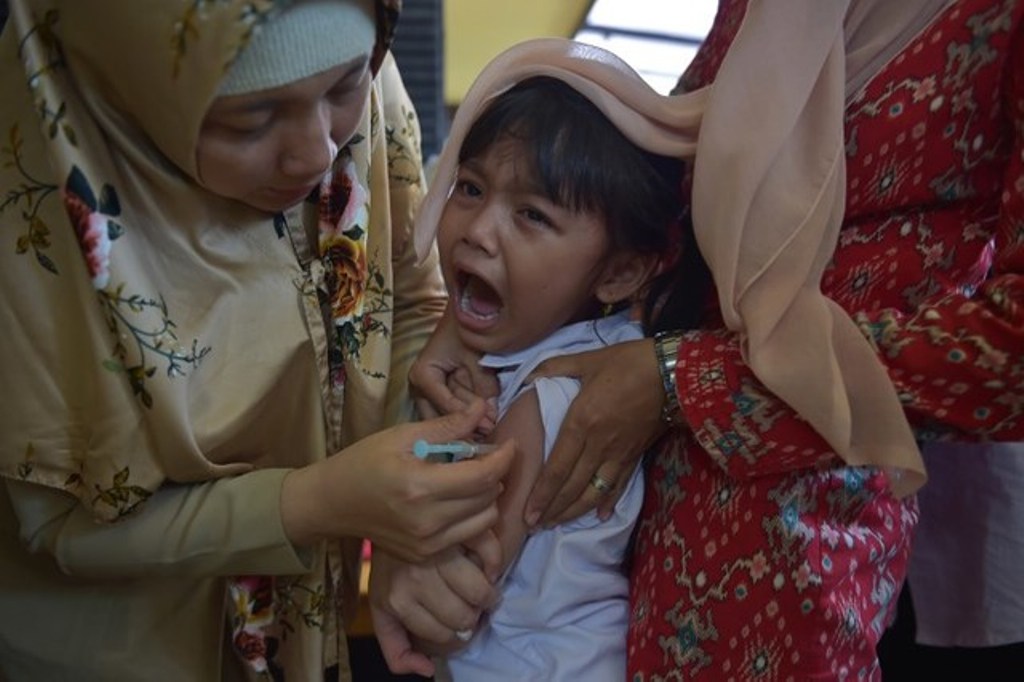 IMMUNIZATION. An Indonesian girl cries as she receives a vaccination shot against diphtheria at a village clinic in Jakarta on December 11, 2017. Adek Berry/AFP.