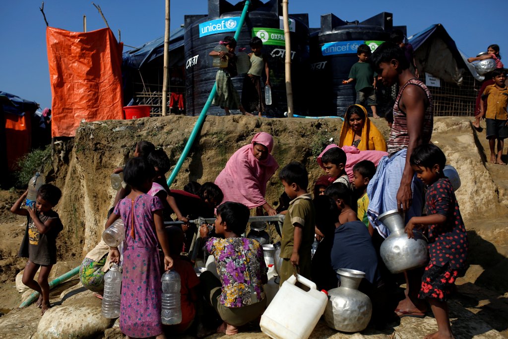 Rohingya refugees fill their containers with water at the Onchiprang refugee camp near Cox's Bazar, Bangladesh December 13, 2017. REUTERS/Alkis Konstantinidis.