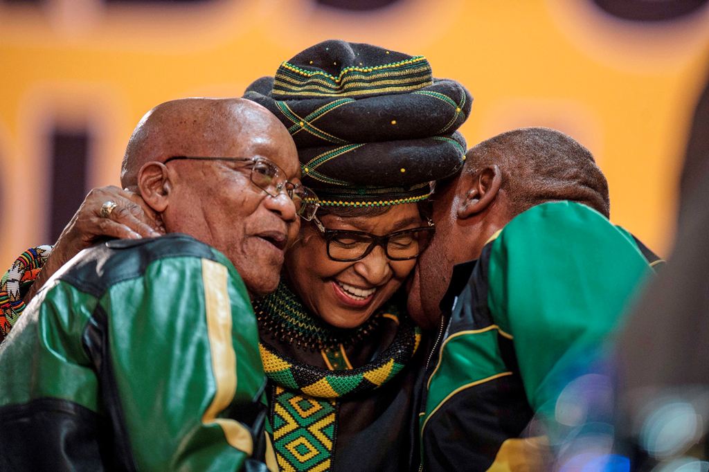 Former wife of the late South African President Nelson Mandela, Winnie Mandela (C), hugs South African President Jacob Zuma (L) and Deputy President Cyril Ramaphosa as they attend the 54th ANC National Conference at the NASREC Expo Centre in Johannesburg 