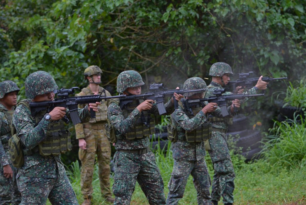 An Australian soldier (back L) supervises as Philippine Marines fire their weapons during a demonstration at Military Operation Urbanized Terrain (MOUTH) training exercises at the marine base in Ternate, Cavite province, southwest of Manila on December 18