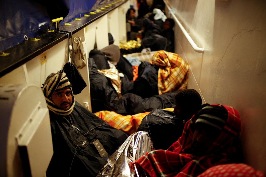 Migrants rest on the MV Aquarius, a search and rescue ship run in partnership between SOS Mediterranee and Medecins Sans Frontieres, as it approaches the Italian island of Sicily after rescue operations in the central Mediterranean off the coast of Libya,