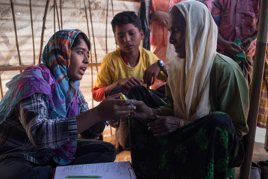 In a photo taken on November 30, 2017, a Rohingya woman is instructed on how to use a rape device issued by the Moonlight Development Society at a clinic in the Chakmarkul refugee camp in Cox's Bazar. AFP / Ed JONES 