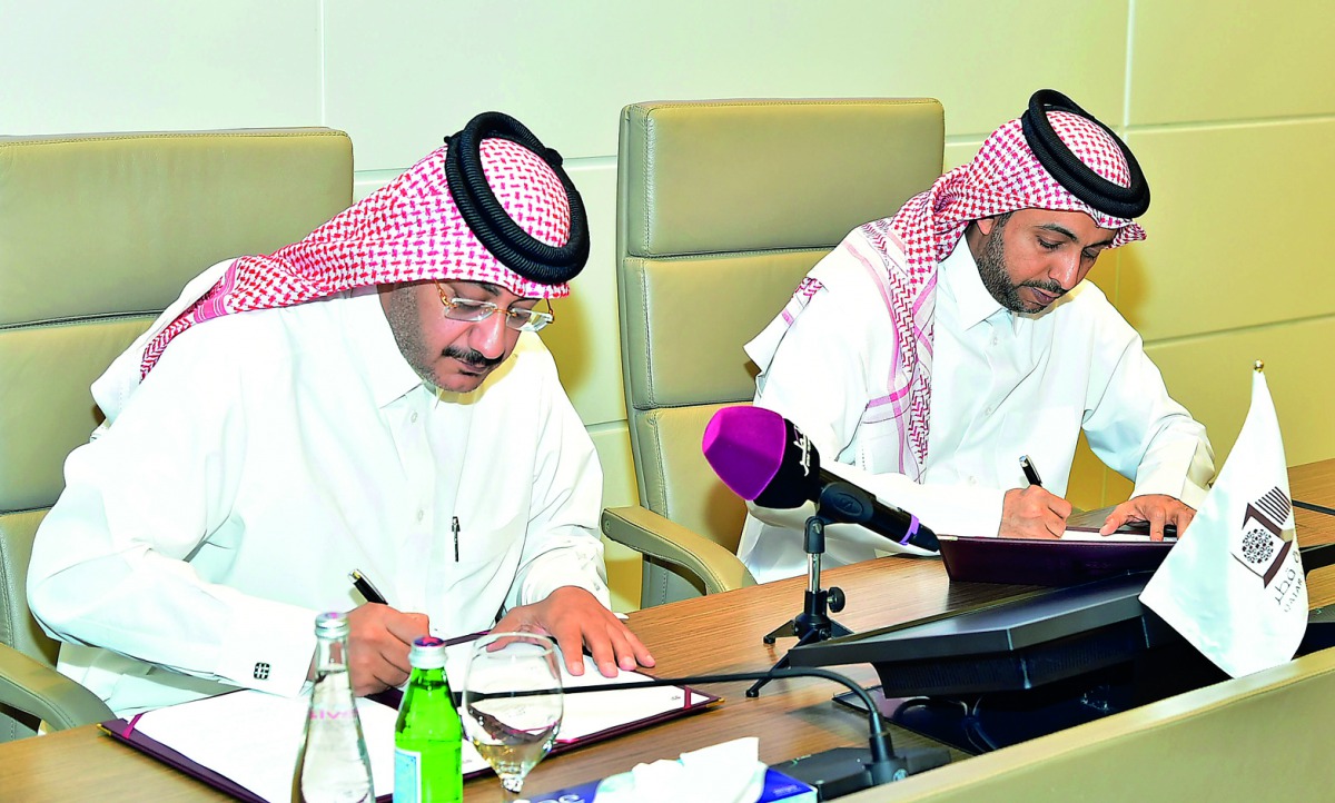 Dr Hassan Al Derham, President of Qatar University (right), and Faleh Al Naemi, Chairman and Managing Director of Qatar Post, signing the MoU. 