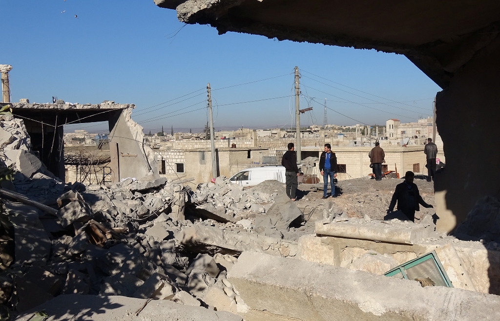 Residents inspect the debris of buildings after the airstrikes over Jarjanaz District of Idlib in Syria on December 26, 2017. Muaz Yemen - Anadolu