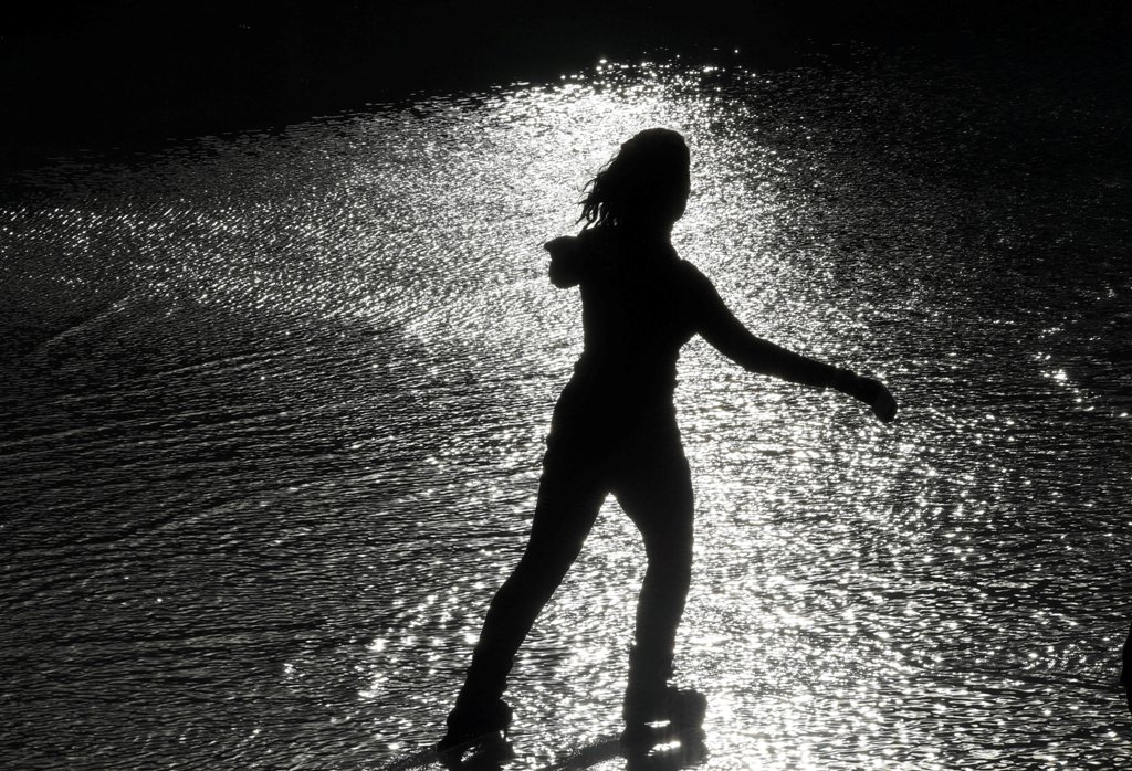 A woman skates in the sun over wet ice following heavy rain showers at the Tower of London ice rink in London, Britain, December 29, 2017. REUTERS/Toby Melville
