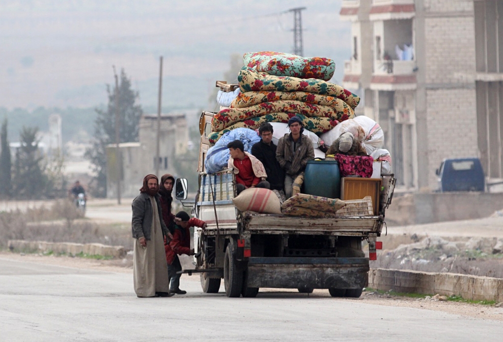 A displaced family from a village in southern Idlib repair their vehicle as they head on the Damascus-Aleppo motorway towards the northern part of the rebel-held province on December 29, 2017. / AFP / OMAR HAJ KADOUR