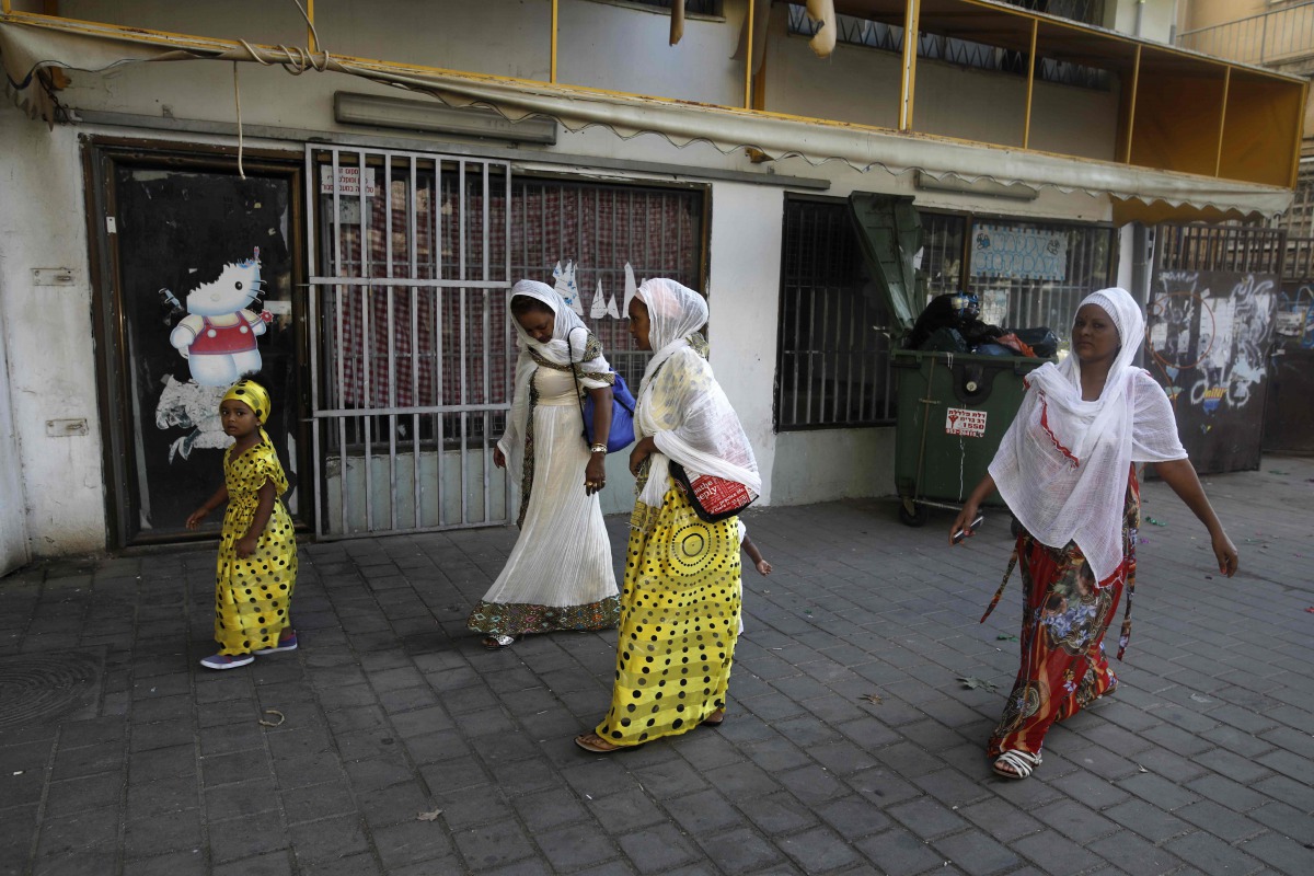 This file photo taken on September 02, 2017 shows Christian African Eritrean migrants walking outside at a makeshift church in southern Tel Aviv. Israel plans to force tens of thousands of African migrants to leave over the next three months by threatenin