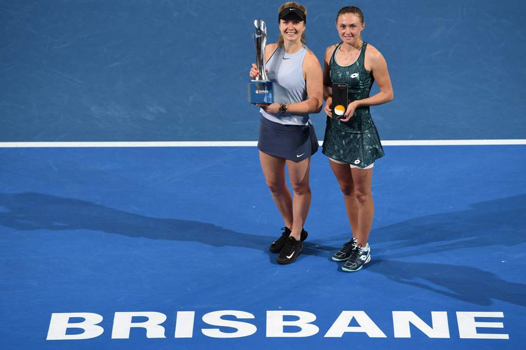 Elina Svitolina of Ukraine (L) holds up the winner's trophy beside Aliaksandra Sasnovich of Belarus after winning their women's singles final of the Brisbane International tennis tournament at the Pat Rafter Arena in Brisbane on January 6, 2018.  AFP / Sa
