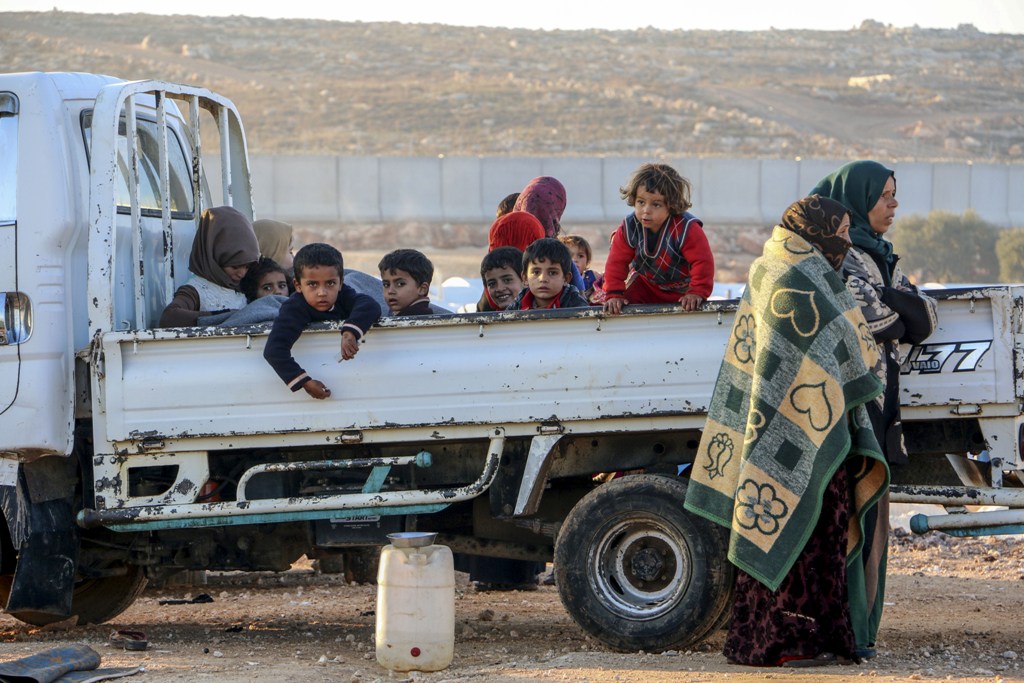 Syrian children are seen on the back of a truck as two old women stand by it in Idlib, Syria on January 09, 2018.  Muhammed Abdullah - Anadolu

