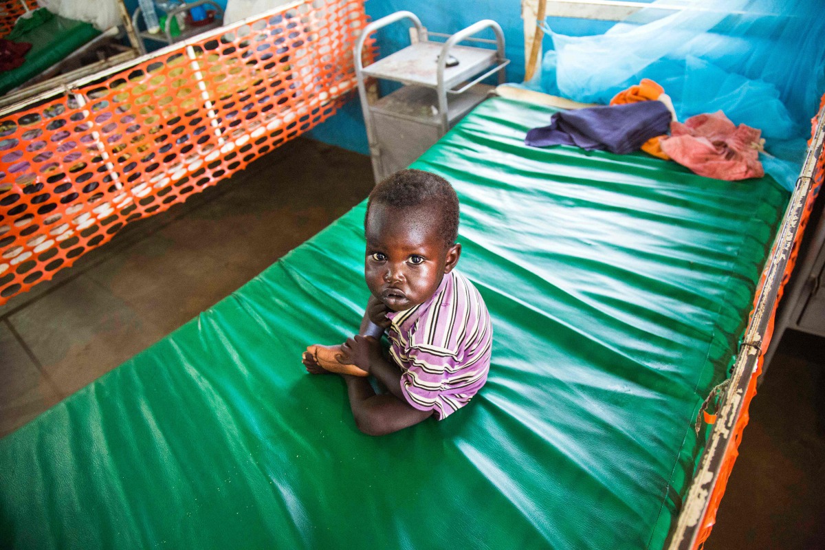 A malnourished child sits on May 30, 2017 on a bed at the clinic run by Doctors Without Borders in Aweil, Northern Bahr al Ghazal, South Sudan. (AFP / Albert Gonzalez Farran) 