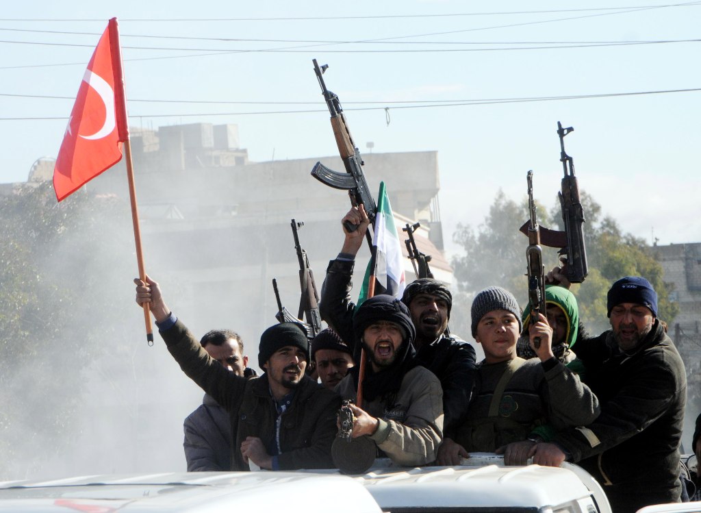 Members of Free Syrian Army (Turkey-backed) fighters tour with their guns as they hold Turkish and their flag in the Syria city of Azez, near the Syrian-Turkish border, 19 January 2018. EPA/HASAN KIRMIZITAS
