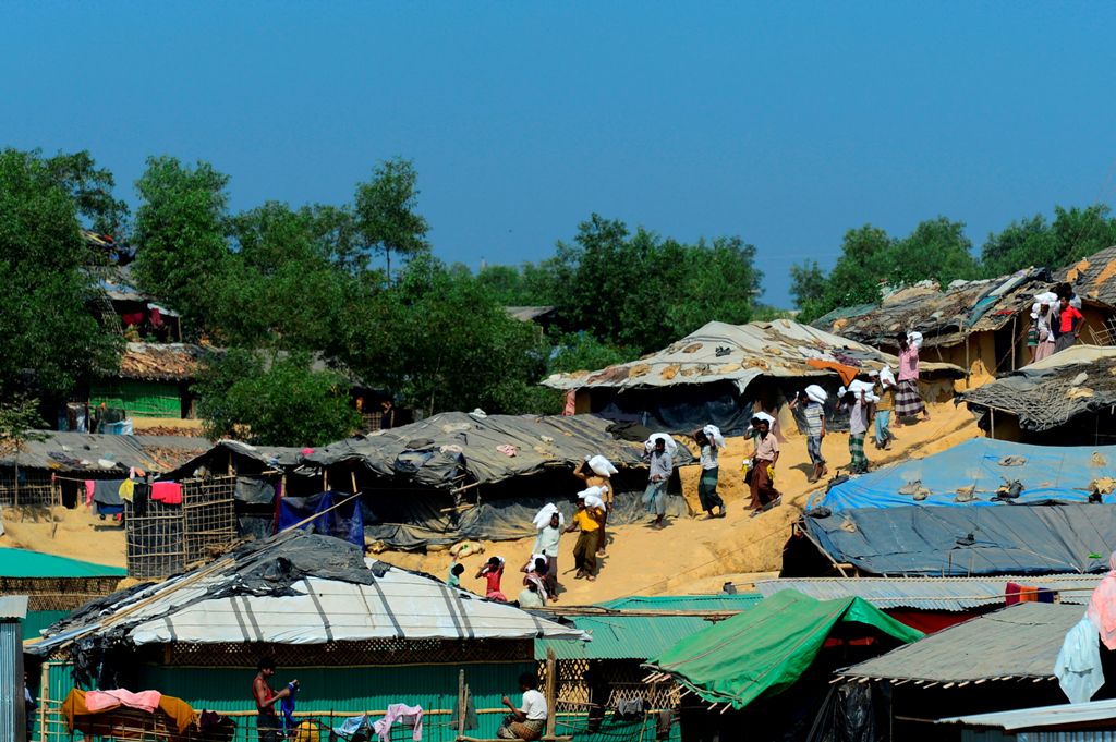 Rohingya Msulim refugees carry relief material at Kutupalong refugee camp in Bangladesh's Ukhia district on January 23, 2018. AFP / Munir UZ ZAMAN
