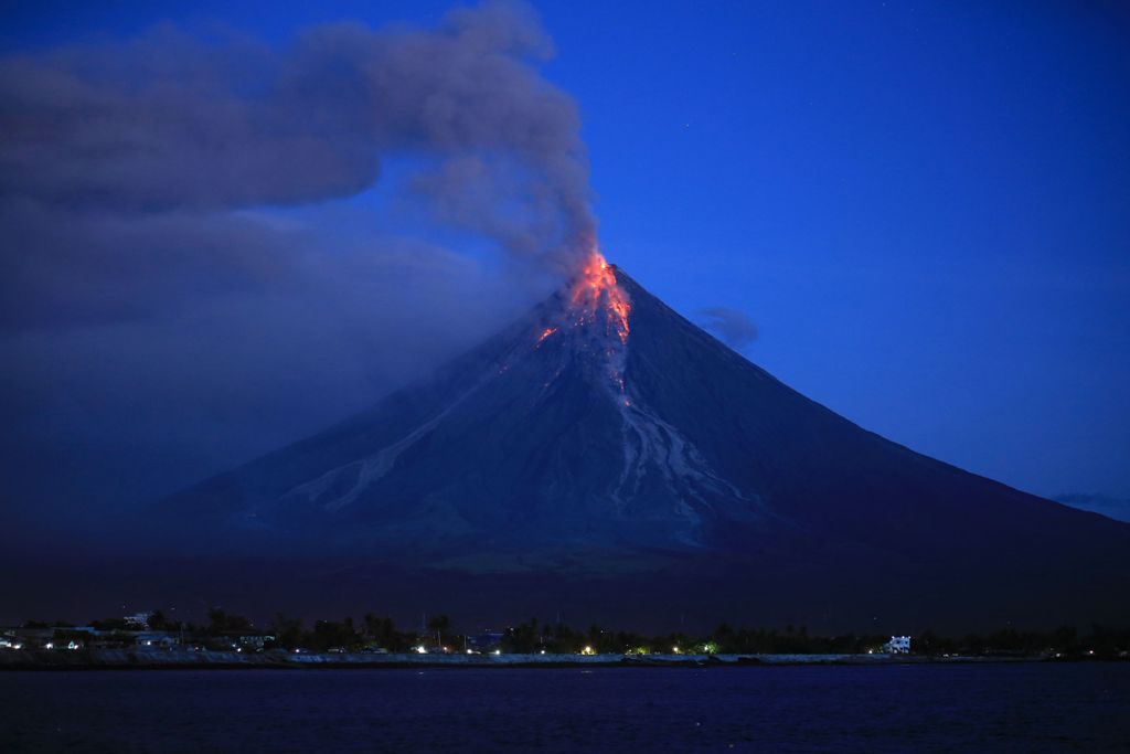 Lava spews from the Mayon volcano as it continues to erupt, seen from Legazpi City in Albay province, south of Manila early on January 23, 2018.  AFP / CHARISM SAYAT