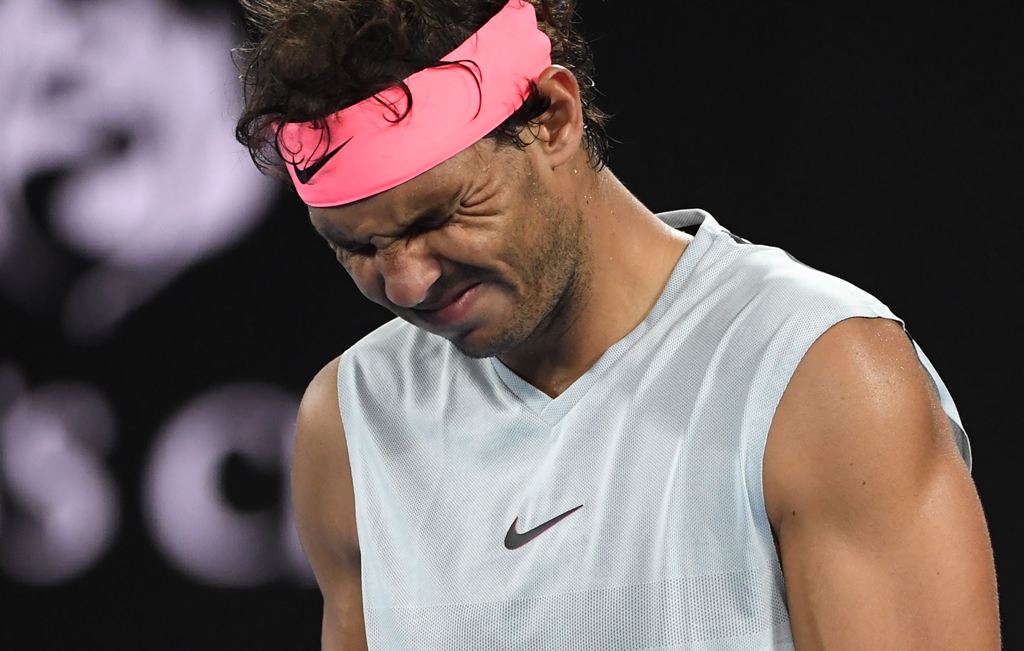 Spain's Rafael Nadal grimaces as he walks on court while preparing to serve to Croatia's Marin Cilic during their men's singles quarter-finals match on day nine of the Australian Open tennis tournament in Melbourne on January 23, 2018. World No.1 Rafael N