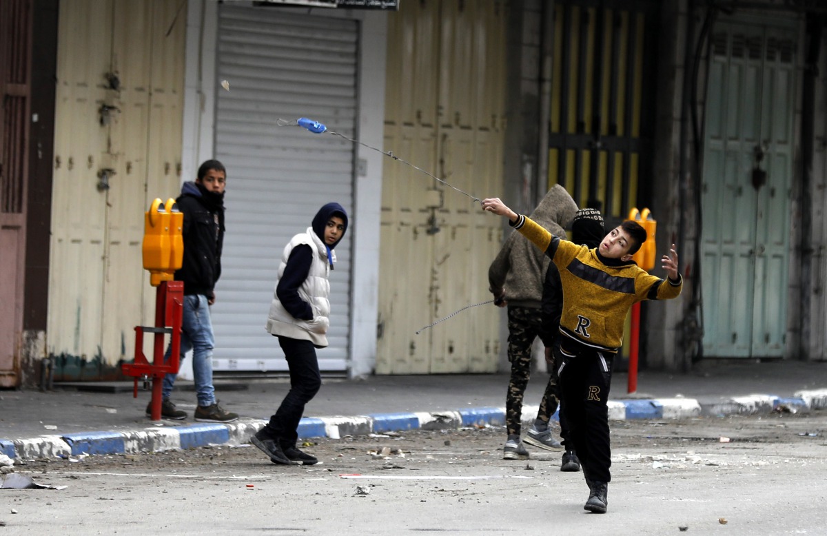 Palestinians hurl stones at Israeli troops during clashes in Hebron, West Bank, 23 January 2018.  EPA/Abed Al Hashlamoun
