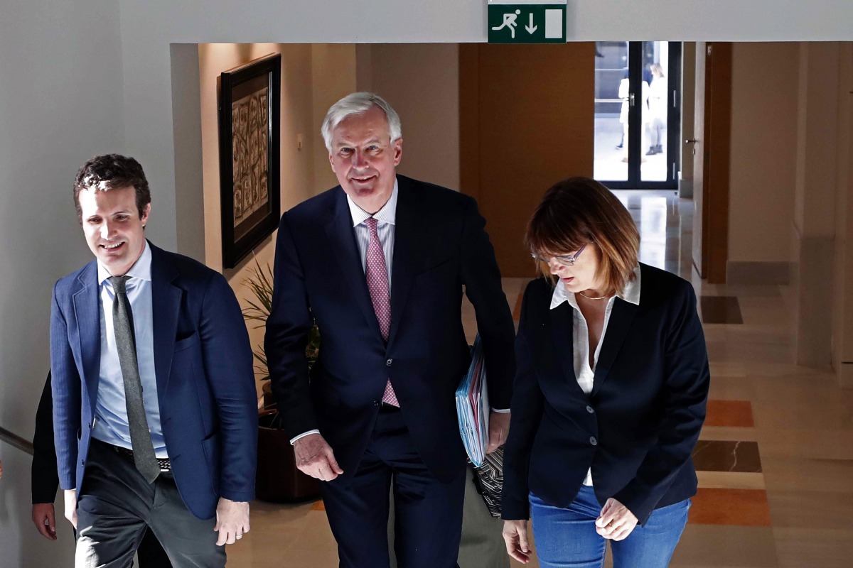 EU Chief negotiator for Brexit, Michel Barnier (C) walks with deputy Secretary of Communication of the People's Party (PP), Pablo Casado (L), and Spokeswoman of the Socialist Group in the Congress of Deputie, Soraya Rodriguez (R), during a European Union 