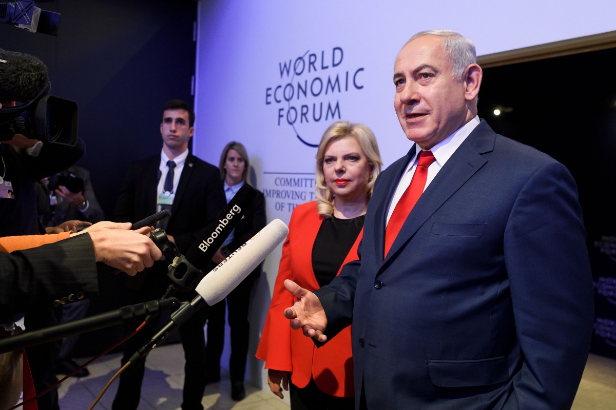 Israeli Prime Minister Benjamin Netanyahu talks to journalist next to his wife Sara during the World Economic Forum (WEF) annual meeting on January 25, 2018 in Davos, eastern Switzerland. AFP / Fabrice Coffrini