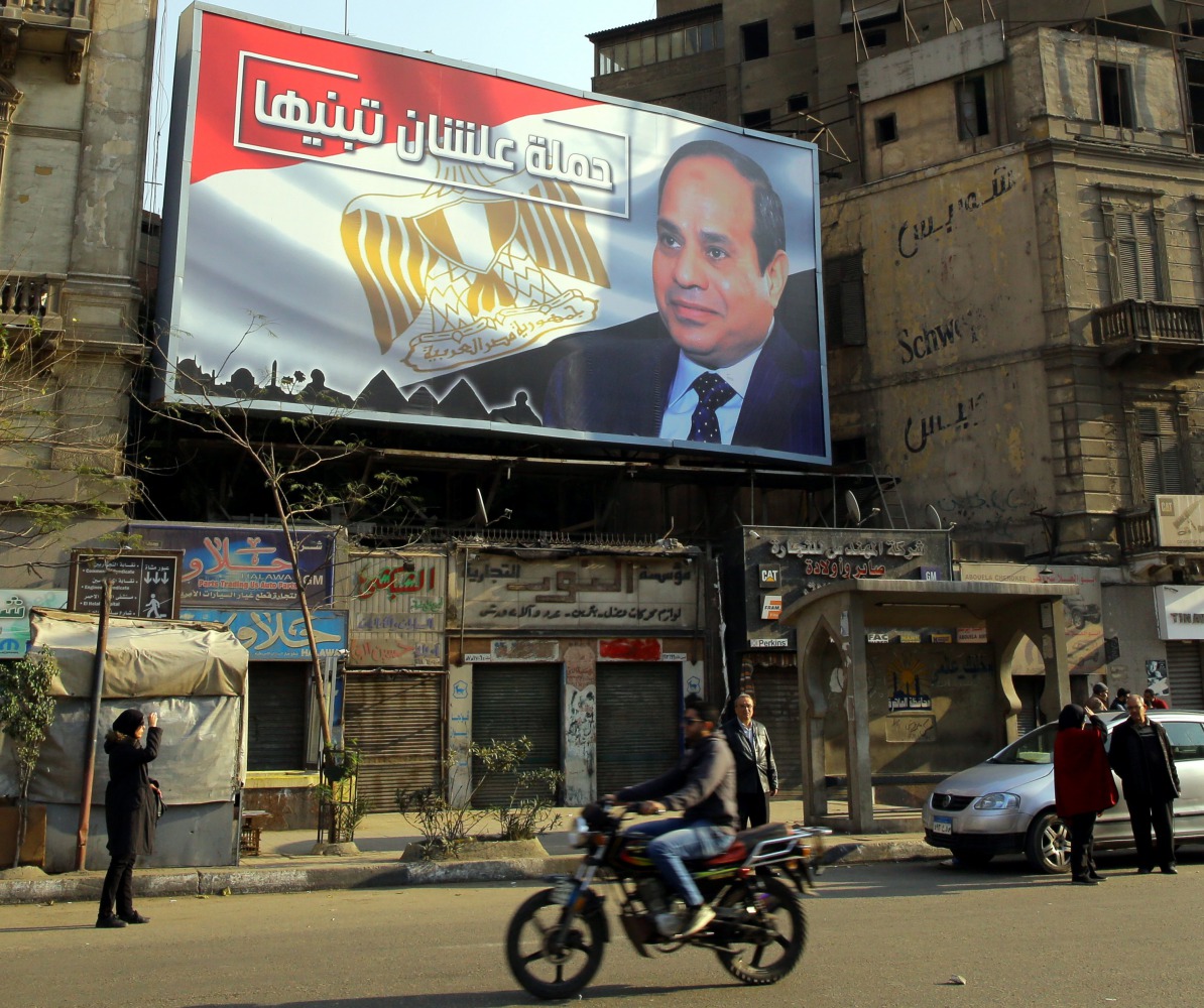 Egyptians walk underneath an election campaign poster erected by supporters of Egyptian President Abdel Fattah al-Sisi, in Cairo, Egypt, 28 January 2018. EPA/Khaled Elfiqi

