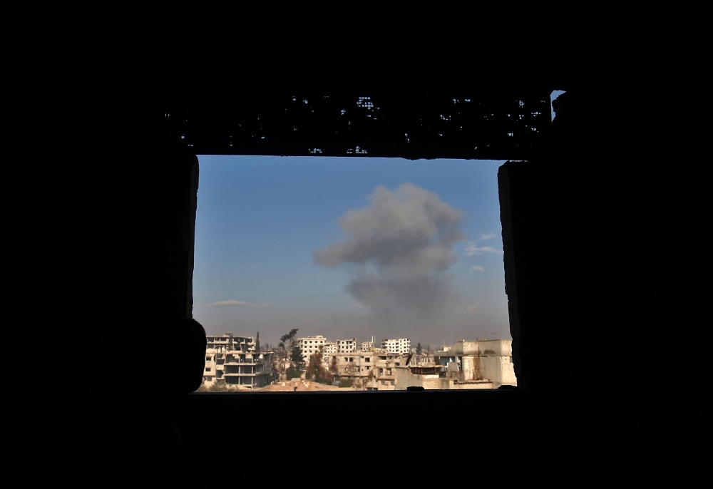 Smoke rises following a reported air strike in the rebel-held Syrian town of Mudayra, in the Eastern Ghouta region on the outskirts of Damascus, on January 28, 2018. / AFP / ABDULMONAM EASSA