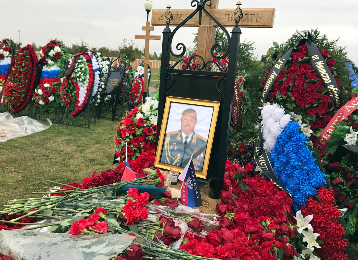 A flag of the separatist self-proclaimed Donetsk People's Republic is seen near a portrait of Russian General Valery Asapov on his grave at a military cemetery near Moscow, Russia October 3, 2017. Reuters/Maria Tsvetkova