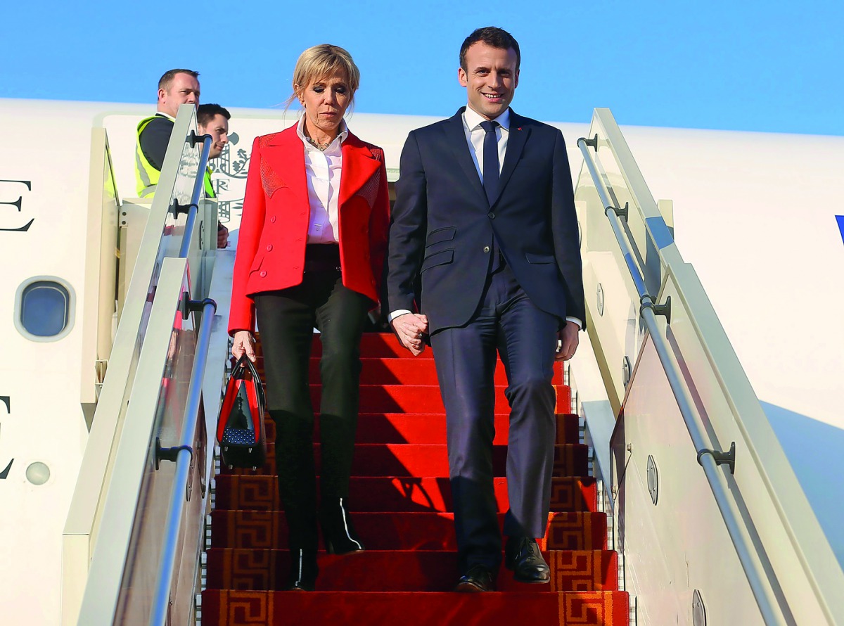 French President Emmanuel Macron (R) and his wife Brigitte Macron descend from an airplane (R) following their arrival at Tunis-Carthage International Airport in Tunis on January 31, 2018. AFP / Zoubeir Souissi