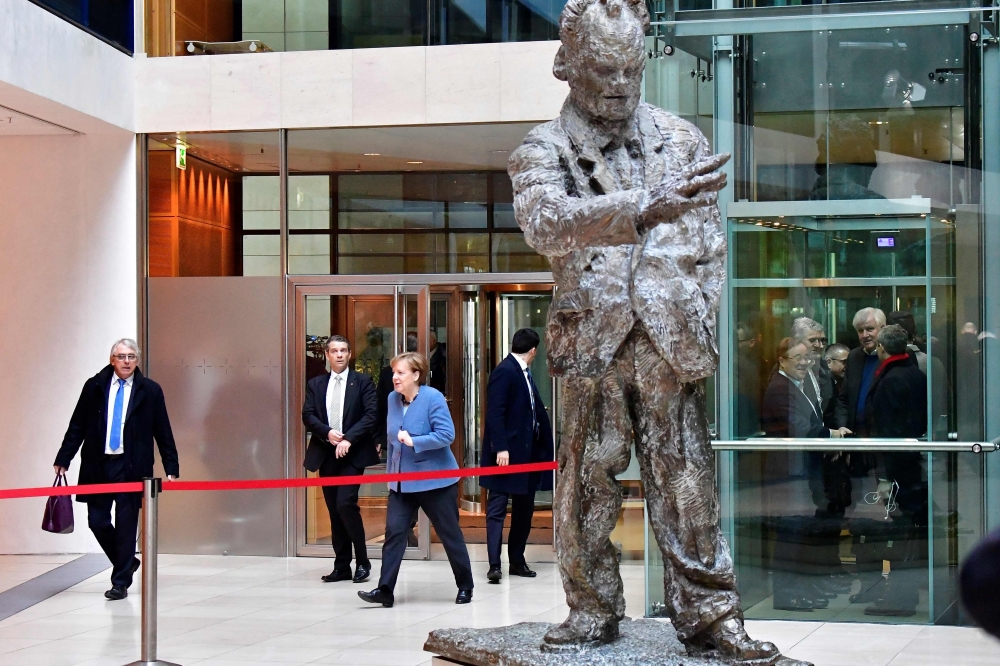 German Chancellor Angela Merkel (3rdL) arrives at the Social Democrats Party (SPD) headquarters as the Chairman of the Bavarian Christian Social Union (CSU) Horst Seehofer (R) takes the elevator on February 4, 2018 in Berlin.  AFP / Tobias Schwarz

