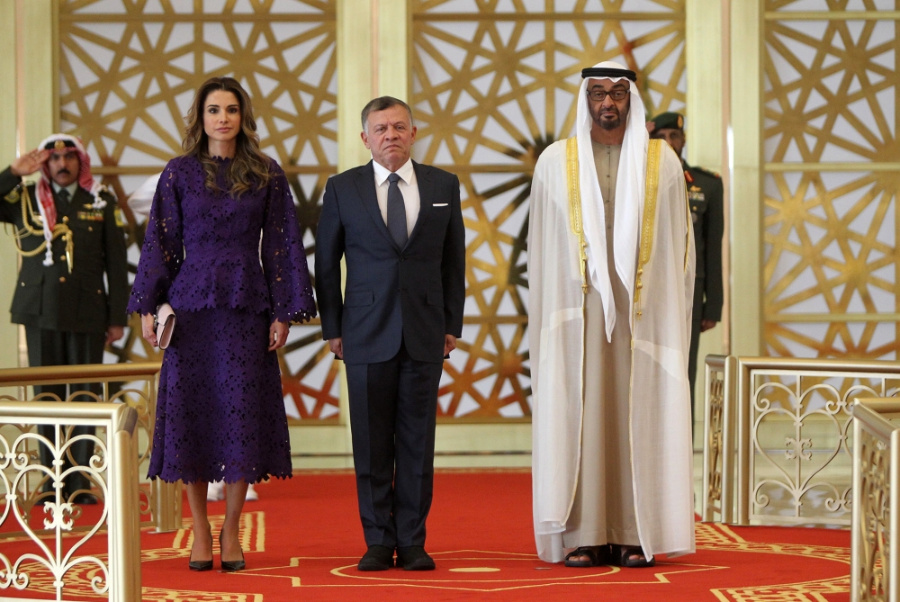 A handout picture released by the Jordanian Royal Palace on February 7, 2018 shows Jordanian King Abdullah II (C) and Queen Rania of Jordan (L) being received by Abu Dhabi Crown Prince Mohammed bin Zayed Al-Nahyan (R) in the capital Abu Dhabi. AFP Photo /