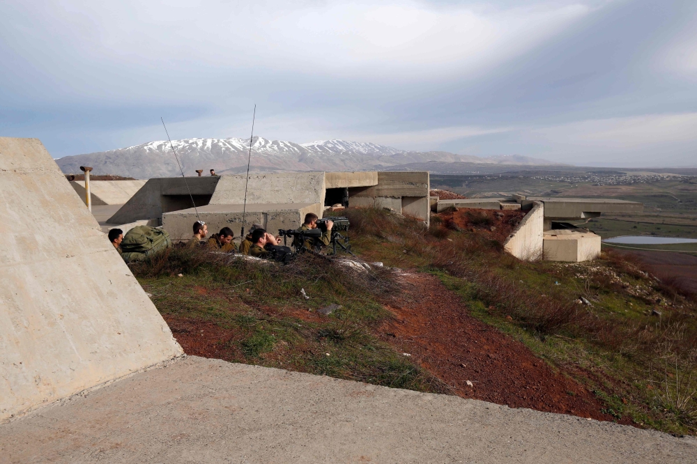 :A picture taken on February 10, 2018 show Israeli solders taking positions in the Israeli-occupied Golan Heights near the border with Syria.  AFP / JALAA MAREY
