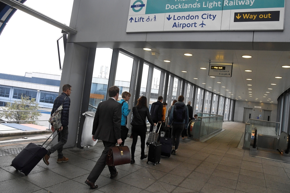 FILE PHOTO: Passengers alight from a train to enter City Airport in London, Britain, October 18, 2017. REUTERS/Toby Melville/File Photo	
