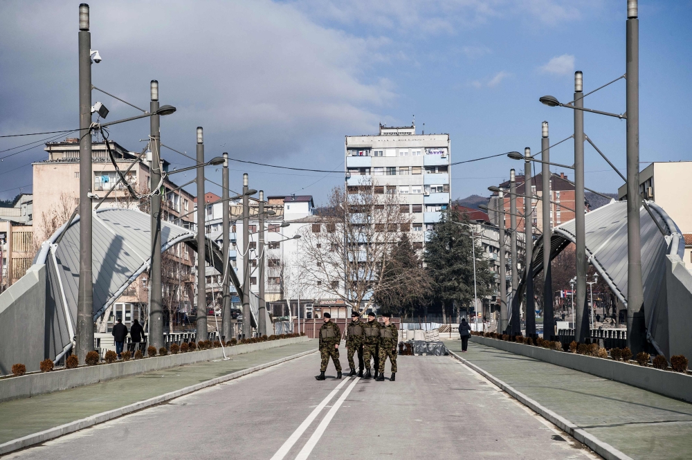 Soldiers of the NATO led-peacekeeping mission in Kosovo cross the main bridge in the divided town of Mitrovica, on February 1, 2018.  AFP / Armend NIMANI