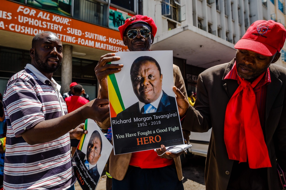 Supporters of the Zimbabwe opposition party Movement for Democratic Change (MDC) hold banners of Morgan Tsvangirai reading 
