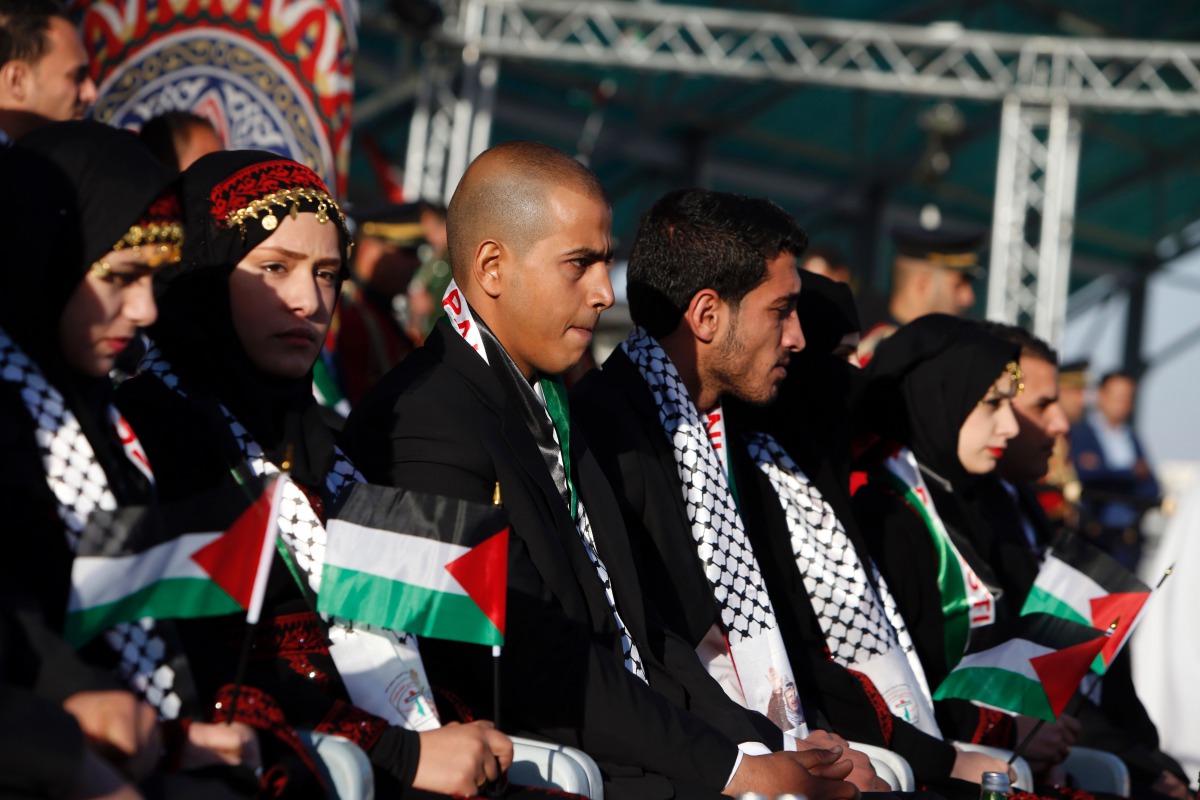 FILE PHOTO: Palestinian couples sit on stage during a group wedding celebration held on November 24, 2016, for 27 couples organised by Fatah movement (AFP / Jaafar Ashtiyeh) 