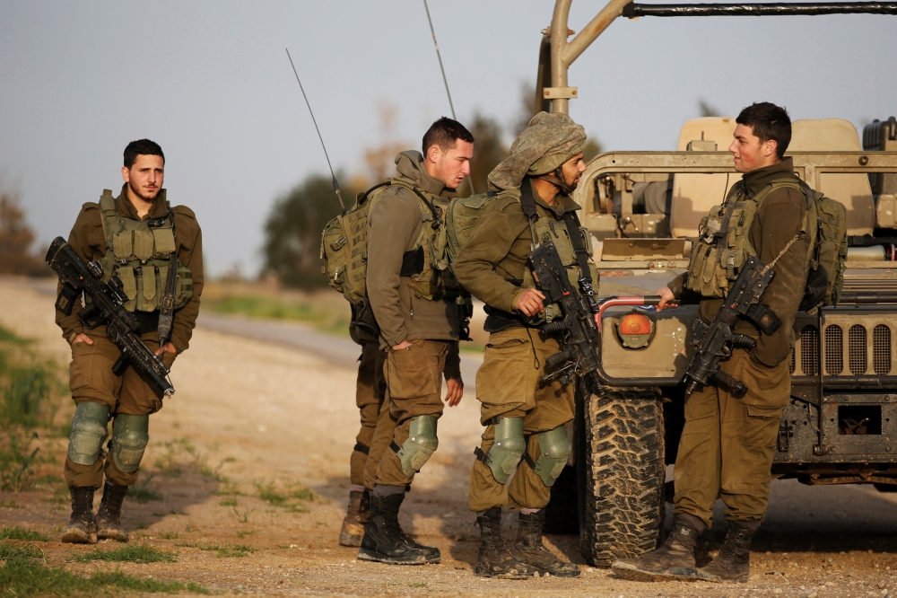 Israeli soldiers stands near a military jeep next to the border fence with the southern Gaza Strip near Kibbutz Nirim, Israel February 17, 2018. REUTERS/Amir Cohen