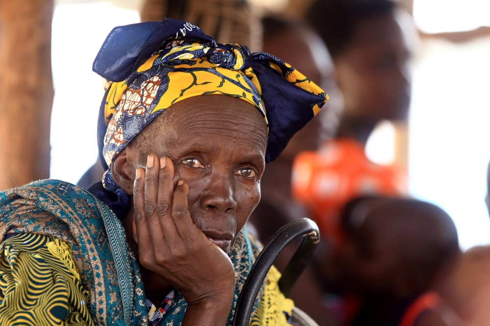 File photo of a Congolese elderly woman, who migrated from Democratic Republic of Congo by fleeing on a boat across Lake Albert, waits to be registered by United Nations High Commission for Refugees (UNHCR) in Ntoroko, Uganda February 17, 2018. REUTERS/Ja