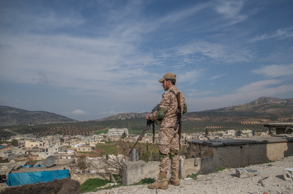 A member of Free Syrian Army, backed by Turkish Armed Forces is seen as he stands guard at Rajo’s town center on March 13, 2018.  Halil Fidan - Anadolu