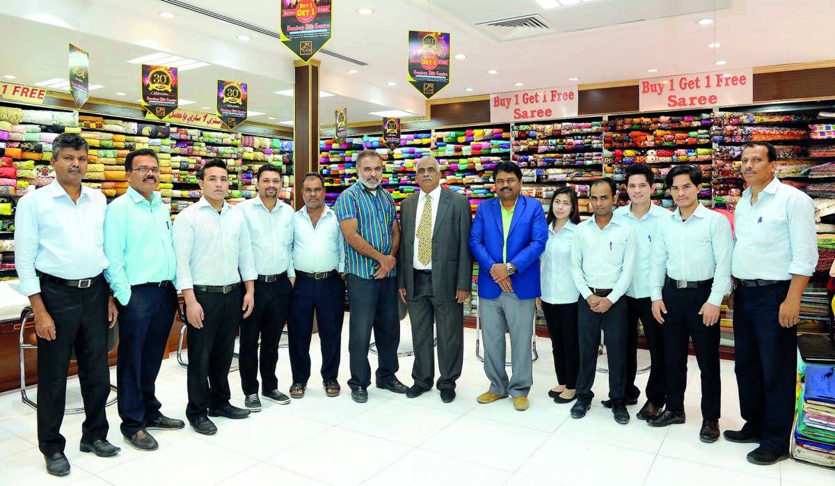 Bekal Mohamed Salih (centre), Managing Director, Bombay Silk Centre and Chairman of BMS Exports (Mumbai), India, with Vipresh Seth (sixth right), General Manager, BSC, and some of the employees of BSC at the showroom.  Pics: Salim Matramkot / The Peninsul