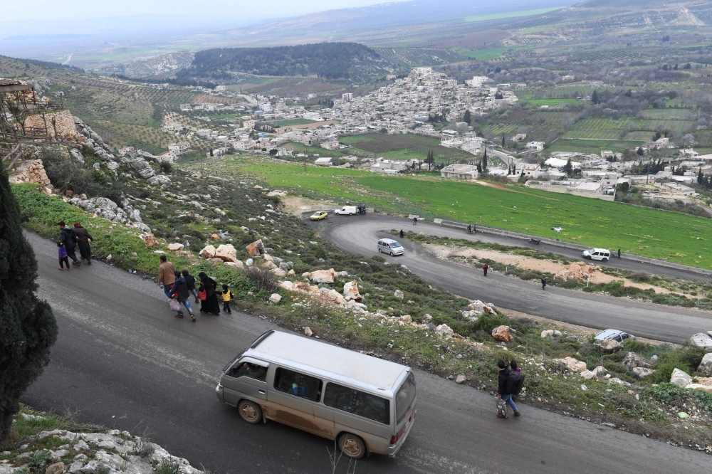 Civilians fleeing the city of Afrin in northern Syria walk at the mountainous road of al-Ahlam while heading towards the check point in az-Ziyarah, in the government-controlled part of the northern Aleppo province, on March 15, 2018 on the way to seek ref