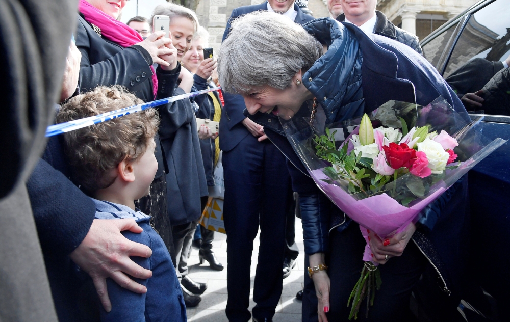 Britain's Prime Minister Theresa May (R) meets members of the public during her visit to Salisbury, southern England, on March 15, 2018, where she visited the areas where former Russian double agent Sergei Skripal and his daughter Yulia went to, and were 