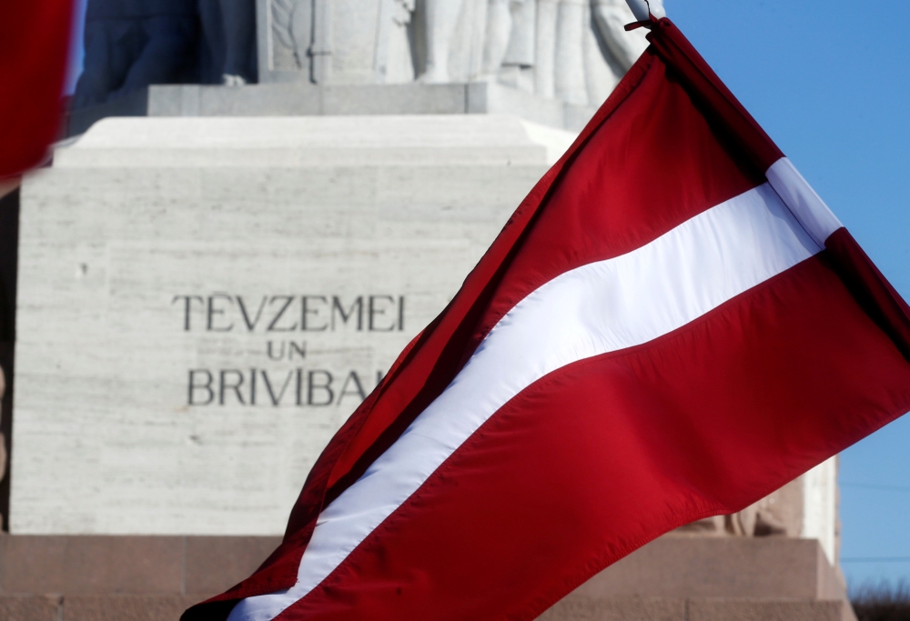 Latvia's national flag flutters next to the Freedom monument in Riga, Latvia March 16, 2018. Reuters/Ints Kalnins