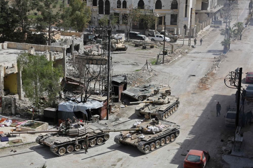 Syrian pro-government forces enter the main square of Kfar Batna, southeastern Ghouta, on the outskirts of the capital Damascus, on March 19, 2018. AFP 
